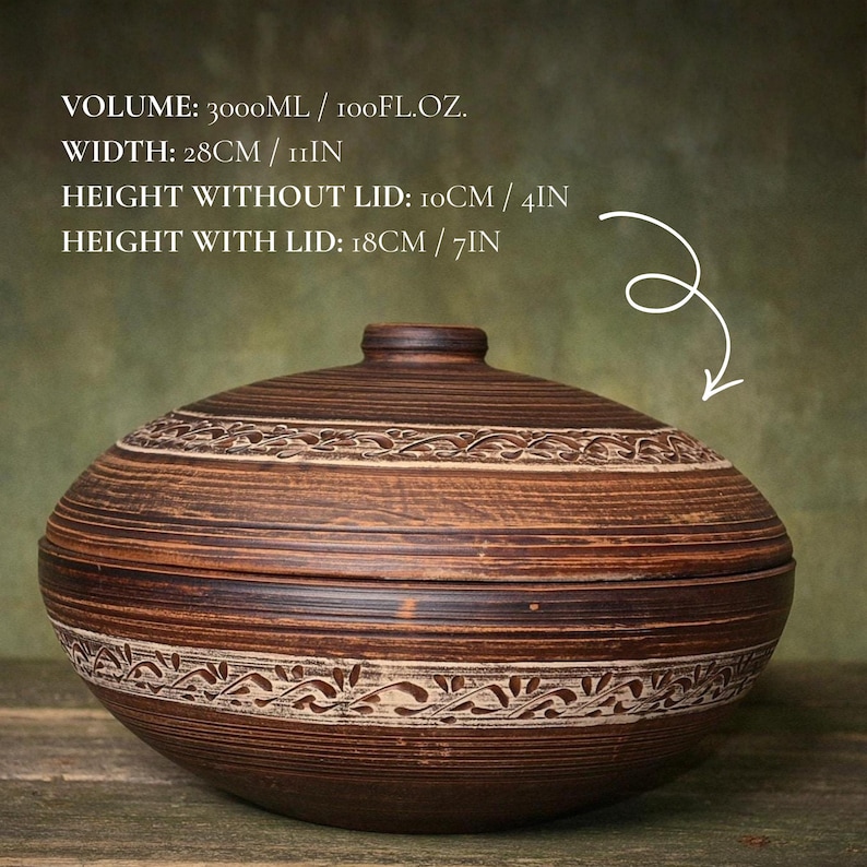 May include: A brown ceramic lidded bowl with horizontal grooves and a carved leaf pattern. Text: VOLUME: 3000ML / 100FL.OZ. WIDTH: 28CM / 11IN HEIGHT WITHOUT LID: 10CM / 4IN HEIGHT WITH LID: 18CM / 7IN. The bowl has a rounded shape and a matching lid.