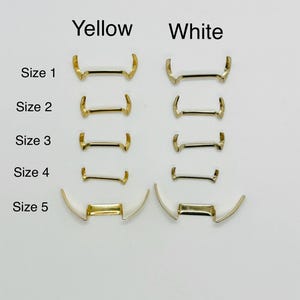 Puede incluir: Cinco tamaños de pasadores de resorte para correas de reloj en metal amarillo y blanco. Los tamaños están etiquetados del 1 al 5.