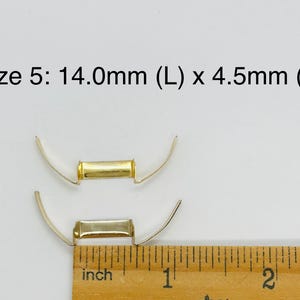May include: Two gold-toned metal clasps, one on top of the other, are measured with a ruler. The ruler shows the top clasp is 14.0mm long and 4.5mm wide.  Size 5: 14.0mm (L) x 4.5mm (W) is written above the clasps.