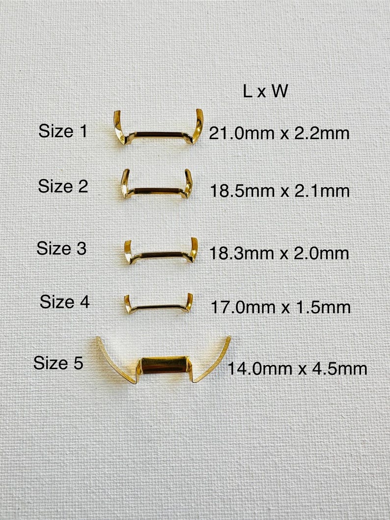 May include: Five sizes of gold metal watch band spring bars, labeled with their length and width in millimeters.  Size 1 is 21.0mm x 2.2mm, Size 2 is 18.5mm x 2.1mm, Size 3 is 18.3mm x 2.0mm, Size 4 is 17.0mm x 1.5mm, and Size 5 is 14.0mm x 4.5mm.