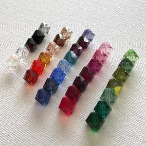 May include: Assortment of 10 faceted crystal beads in various colors, including clear, black, red, orange, yellow, green, blue, purple, pink, and light green.