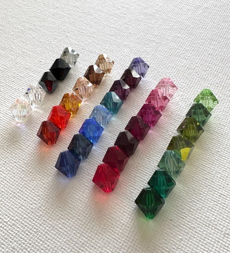 May include: Assortment of 10 faceted crystal beads in various colors, including clear, black, red, orange, yellow, green, blue, purple, pink, and light green.