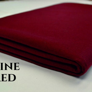 May include: A folded piece of wine red felt fabric. The fabric is smooth and has a slight sheen. The text "WINE RED" is printed below the fabric.