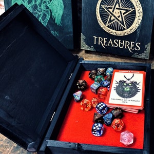 May include: A black wooden box with a red felt interior. The box is open and contains a variety of dice and a card with the text "Talisman of Ultimate Evil".