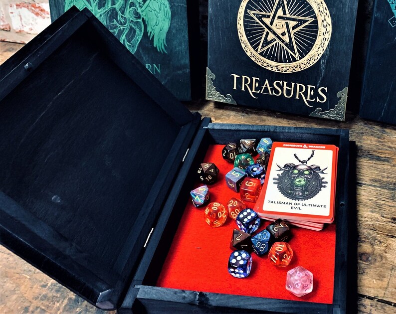 May include: A black wooden box with a red felt interior. The box is open and contains a variety of dice and a card with the text "Talisman of Ultimate Evil".
