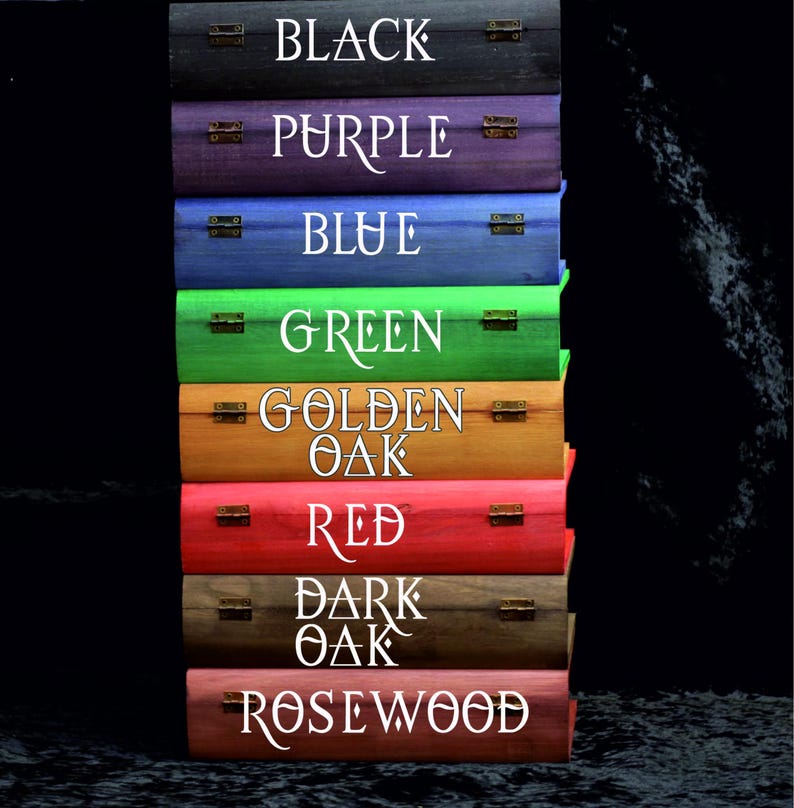 May include: A vertical stack of eight rectangular wooden boxes, each featuring metal hinges and white text labels: Black, Purple, Blue, Green, Golden Oak, Red, Dark Oak, and Rosewood. The boxes are finished in distinct wood stains.