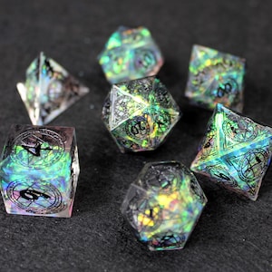 Può includere: Set di dadi iridescenti con numeri neri e un motivo a spirale. I dadi sono realizzati in resina trasparente e hanno una varietà di forme, tra cui un d4, d6, d8, d10, d12 e d20.