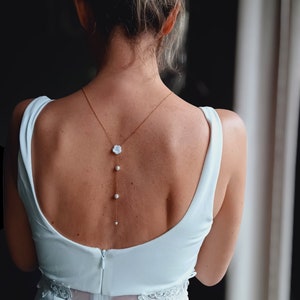 JASMIN- Collar de espalda de acero dorado con cadena fina con perlas blancas y pequeña flor de jazmín blanco en tejido de estilo boho.