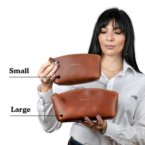 May include: Two brown leather cosmetic bags, one labeled "Small" and the other labeled "Large". Both bags have a zipper closure and a small leather loop.