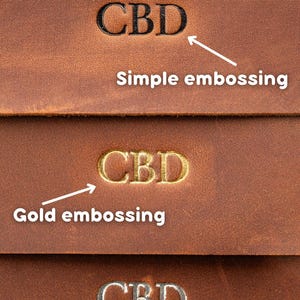 May include: Close-up of brown leather with three different embossed "CBD" designs. The top design is simple embossing, the middle is gold embossing, and the bottom is silver embossing. The image shows the different styles available.