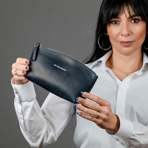 May include: A dark blue leather zippered pouch with the text "Old Town Leather" printed on the front.