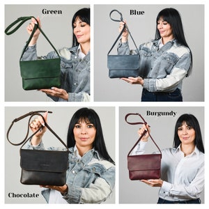 May include: A collection of four rectangular leather crossbody bags with fold-over flaps and adjustable shoulder straps. The bags are shown in four distinct colors: forest green, slate blue, dark chocolate brown, and deep burgundy red.
