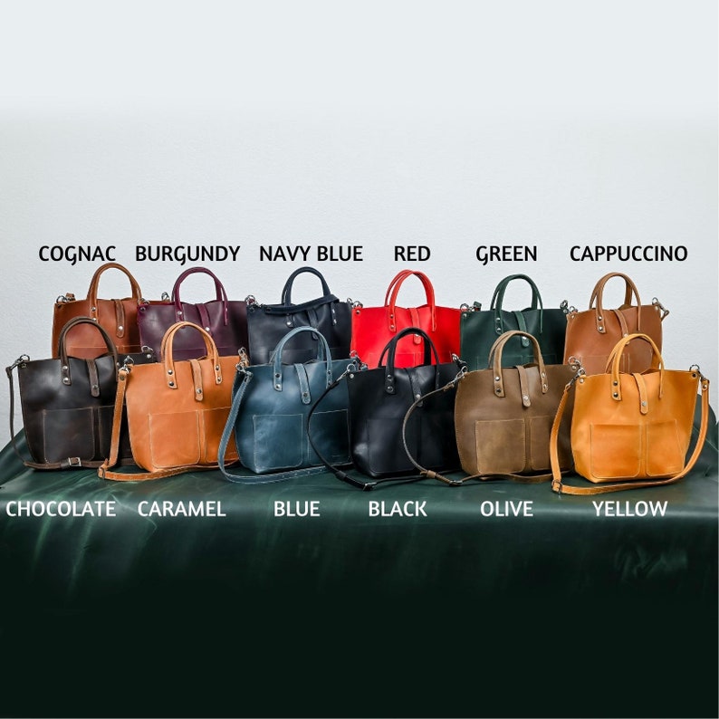 May include: Ten leather tote bags in various colors, including cognac, burgundy, navy blue, red, green, cappuccino, chocolate, caramel, blue, black, olive, and yellow. The bags are arranged in two rows, with the colors labeled below each bag.