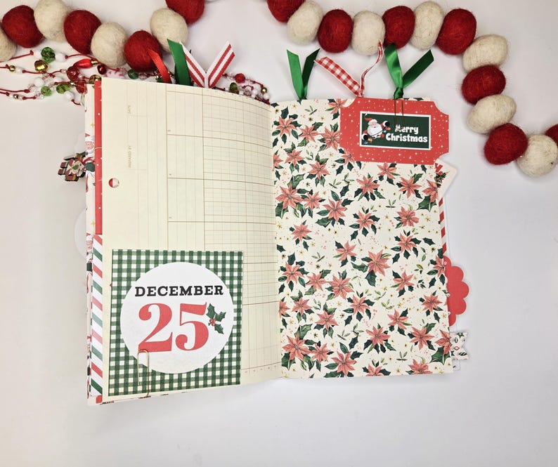 May include: Open journal with Christmas-themed pages. One page has a grid pattern, the other has a floral design. A tag reads "Merry Christmas" with a Santa illustration. The date "December 25" is displayed on a round sticker.