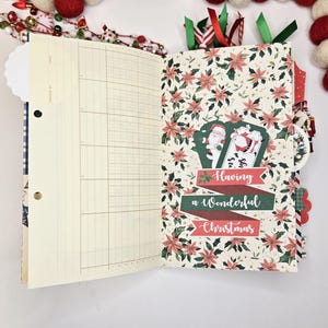 May include: Open journal with lined pages and a Christmas-themed patterned page. The patterned page features red poinsettias and a banner that reads "Having a Wonderful Christmas." Decorative ribbons and embellishments are visible.