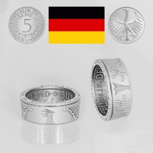 May include: A silver ring made from a 5 Deutsche Mark coin. The ring features the German eagle and the text "Bundesrepublik Deutschland" around the edge. The coin is from 1971.