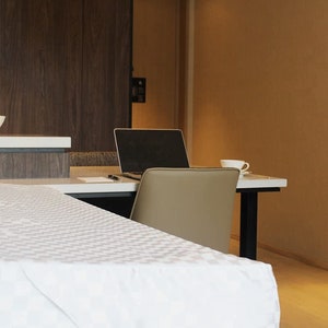May include: A white table with a white tablecloth and a laptop computer on a desk in the background.