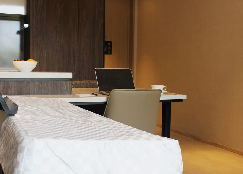 May include: A white table with a white tablecloth and a laptop computer on a desk in the background.