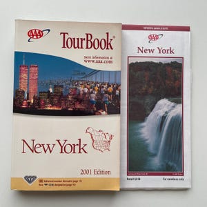 May include: Two AAA New York TourBook guides. The left guide features the Twin Towers and a marathon, with text "TourBook" and "New York 2001 Edition". The right guide shows a waterfall and reads "New York" and "For members only".