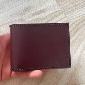 Portefeuille en cuir pour homme de couleur rouge avec compartiments pour cartes, pièces de monnaie, billets de banque, calendriers. Le portefeuille est personnalisé avec des initiales. Fabriqué en Ukraine.