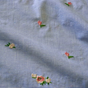 Bordado floral sobre lino y algodón de raya diplomática azul