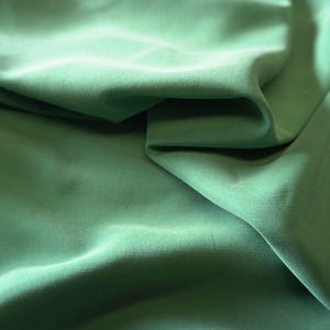 May include: A white ceramic mug with a black handle and the text "But First, Coffee" in a bold, black font. The mug is filled with a dark liquid, likely coffee, and sits on a light-colored surface.