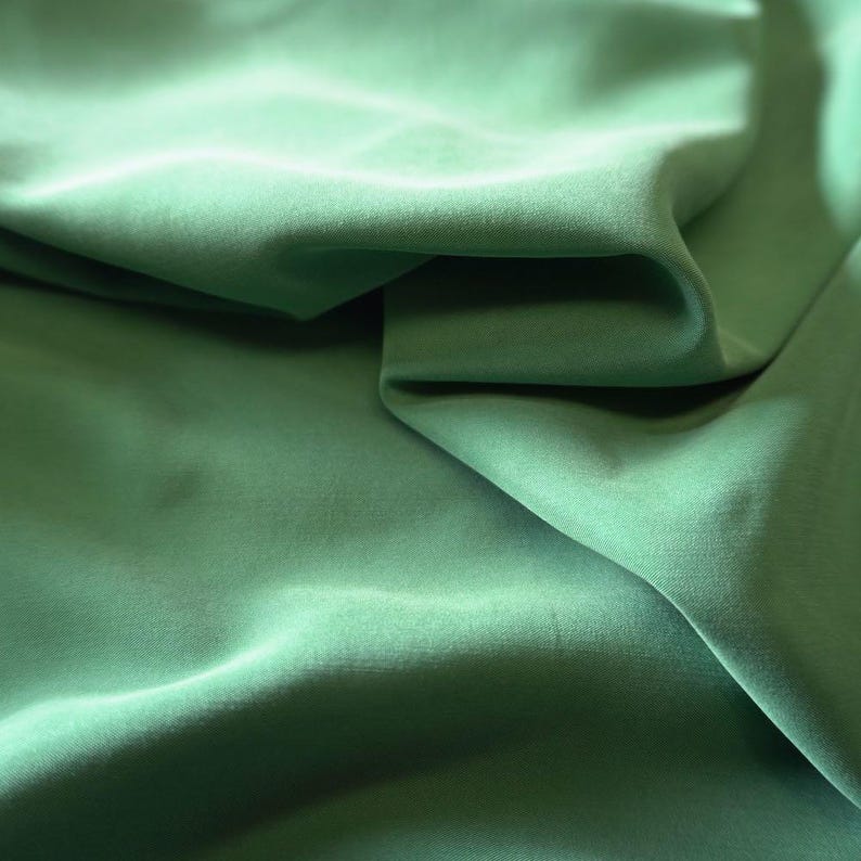 May include: A white ceramic mug with a black handle and the text "But First, Coffee" in a bold, black font. The mug is filled with a dark liquid, likely coffee, and sits on a light-colored surface.