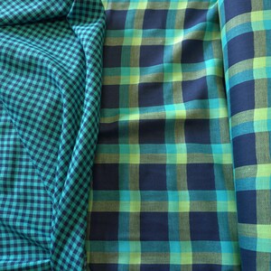 May include: Three fabrics are displayed. The first is a teal and navy blue gingham. The second is a plaid in navy, teal, and lime green. The third is a rolled fabric with a similar plaid pattern, suitable for clothing or home decor.