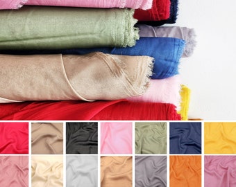 May include: A stack of 10 different colored fabric swatches. The swatches are all the same size and are arranged in a vertical stack. The colors of the swatches are: pink, green, beige, red, yellow, blue, gray, orange, light pink, and cream.
