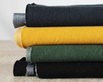 May include: A stack of four fabric swatches in black, yellow, green, and black. The swatches are folded and arranged in a pile.