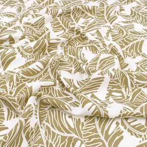 Puede incluir: Tela blanca con un patrón repetitivo de grandes hojas beige estilizadas.
