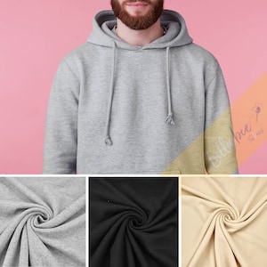 Pode incluir: Uma sudadera com capuz cinza, preta e bege com cordão. O tecido é mostrado em uma imagem de close-up.
