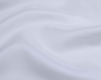 May include: A smooth, white fabric with soft folds and wrinkles. The fabric is light and airy, with a subtle sheen.