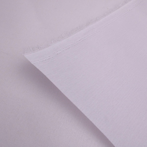 May include: A close-up of a section of light purple fabric. The fabric is folded over, revealing a textured surface and a raw edge with visible threads. The fabric appears to be a lightweight material, possibly linen or cotton.