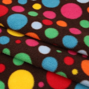 May include: Brown fabric with a repeating pattern of colourful polka dots. The dots are various sizes and colours, including red, blue, green, yellow, and pink.