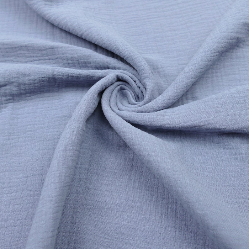 Pu&ograve; includere: Un primo piano di un tessuto morbido e blu con una texture stropicciata. Il tessuto &egrave; in cotone ed &egrave; perfetto per una variet&agrave; di progetti di cucito.