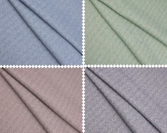 Puede incluir: Cuatro muestras de tela en diferentes colores y patrones. Las muestras están dobladas por la mitad y muestran un patrón de espiga. Los colores son azul, verde, marrón y gris.