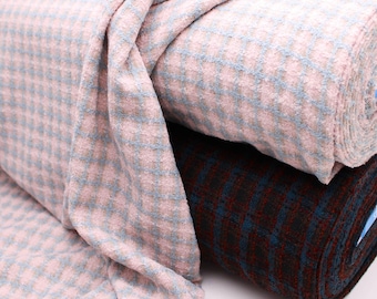 May include: Two rolls of fabric with a checkered pattern. The top roll is pink with light blue checks, and the bottom roll is dark blue with red checks.