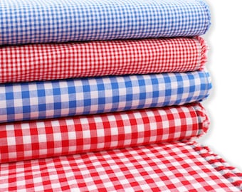 Könnte beinhalten: Vier Lagen Gingham-Stoff in Rot und Blau. Der Stoff ist gefaltet und gestapelt, wobei die unterste Lage ausgebreitet ist.