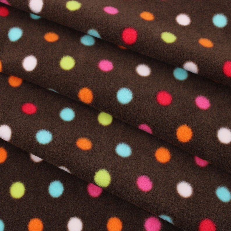 May include: Brown fabric with a polka dot pattern. The dots are in various colours, including red, orange, yellow, green, blue, and white.