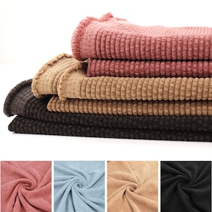 Puede incluir: Muestras de tela de pana de cuatro colores diferentes. Los colores son rosa, marrón, marrón oscuro y azul claro.