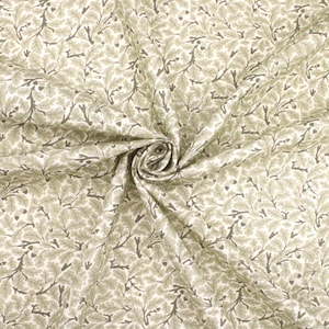 May include: Close-up of fabric featuring a repeating pattern of olive green leaves and branches on a cream background. The fabric is gathered in a swirl, showing the texture and drape. The design evokes a natural, botanical theme.