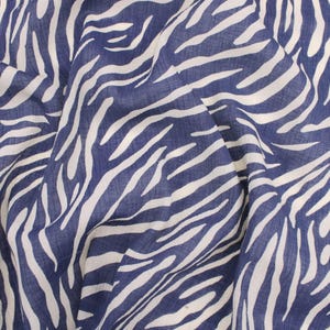 May include: A close-up of a blue and white fabric with a zebra print pattern.