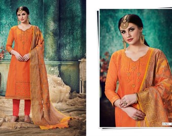 May include: An orange salwar kameez ensemble featuring a long-sleeved tunic with embroidered details, paired with matching pants and a patterned scarf. The outfit is worn by a person, showcasing the traditional Indian attire.