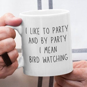 May include: White ceramic mug with black text that reads "I like to party and by party I mean bird watching".
