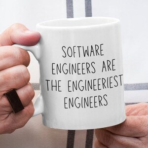 Puede incluir: Taza de cerámica blanca con texto negro que dice "Software Engineers are the Engineerist Engineers".