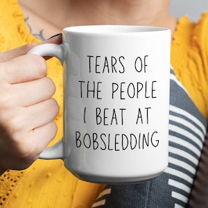 Puede incluir: Taza de café de cerámica blanca con texto negro que dice "Tears of the people I beat at Bobsledding".