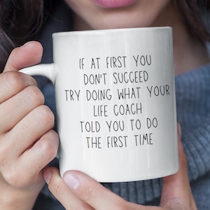 May include: White ceramic mug with black text that reads "If at first you don't succeed try doing what your life coach told you to do the first time."