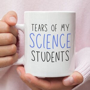 Puede incluir: Taza de cerámica blanca con texto negro que dice "Tears of my Science Students" en una fuente divertida. La palabra "Science" está en azul.