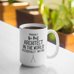 May include: White ceramic coffee mug with black text that reads "Probably the best architect in the world potentially. Maybe." and a compass symbol at the bottom.